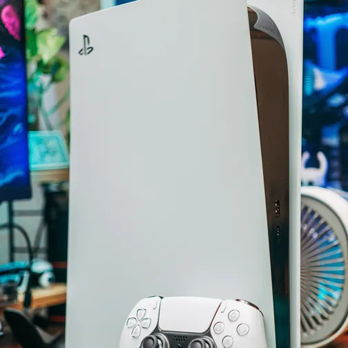 A PlayStation 5 console standing upright with its DualSense controller — PS5 repairs are done at the Jimmy bench in Al Barsha 1