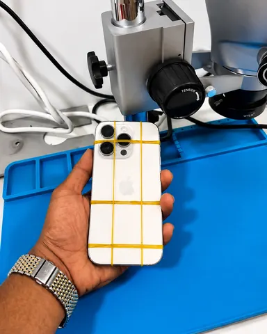An iPhone Pro clamped and setting after a back-glass repair at Jimmy in Al Barsha 1