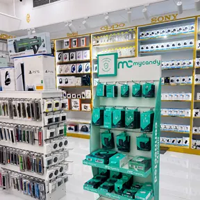 Headphones, earbuds and boxed PlayStation consoles on the shelves at Jimmy in Al Barsha 1